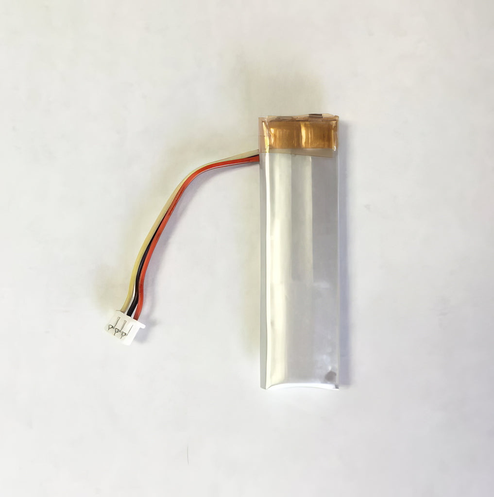 A small DermLite battery for Dermlite GL with a wire attached to it.