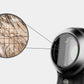 A close-up view of a DermLite DL5 Contact Plate (w/ Grid Reticle) with a magnified inset showing trapped hairs and debris on a 10x10mm grid.